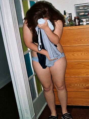 A bitch in panties, her tits out, with one hand on her cunt and the other on her hip, stares at her fucking-ass reflection in a goddamn mirror while she's wearing nothing but a bra and some jeans.