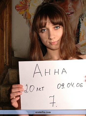 A naked broad holds up an obscene placard, flashing her tits and pussy like it ain't no thang.