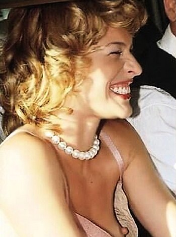 "A hot babe with a tight dress and a fucking expensive pearl necklace, grinning like an asshole as she sits in a friggin' luxury car."