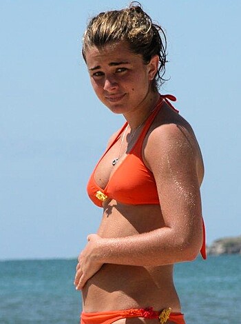 """
Here's a fucking hot babe in her tight orange two-piece, soaking up some sun on the sandy shore. Damn, those titties look amazing in that top! Fuck me running, I need to get to the beach stat. "" 

(31 words)