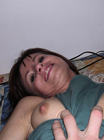 Here's a picture of a chick jerking off with one hand on a bed.