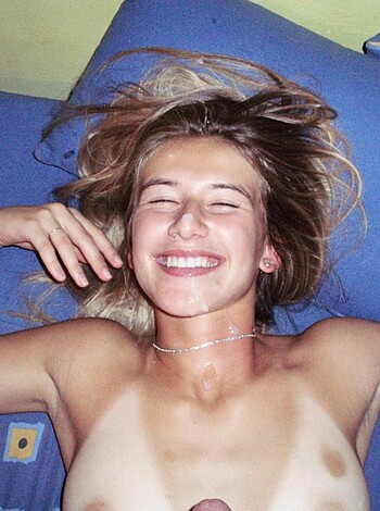 A naked bitch grinnin' on her back with cum all over her face.
