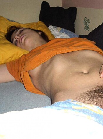 A hot bitch is showing off her fat ass and boobs while lying down on her back, fingering her pussy.