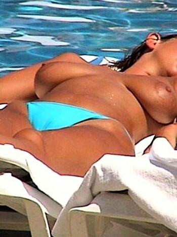 "This fucking hot babe is lounging on the sand, her tits out and ass cheeks hanging out of a skimpy bikini."