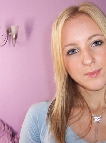 A bitchy blonde chick flashes her cunt-like blue eyes as she smiles for the fuckin' camera.