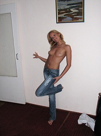 Vulgar description of the image: "A fucking hot topless blonde bitch poses seductively in her tight jeans and sexy high heels, with one hand on her slutty hip and the other finger pointing at the ceiling."