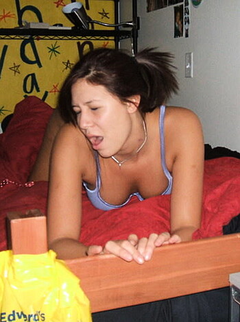 "This picture shows a fucking hot chick with a purple t-shirt covering her pussy while she's lying nude on some frigging red bedsheets, probably getting ready to suck some dick or get fucked in the ass."
