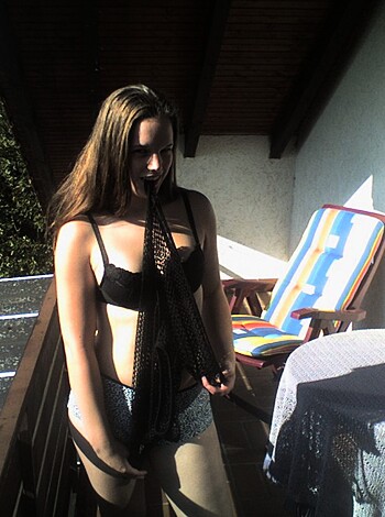 A naked bitch with a rack stans on her balcony.