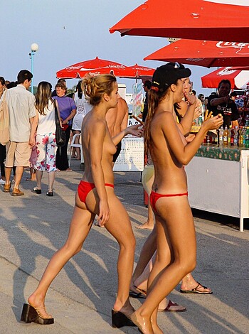 This picture shows two smokin' hot chicks strutting their tits and asses on the boardwalk, completely au naturel.