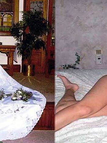 A nude chick is laying on her back while a dressed-up bride is sitting beside her, with her hand placed on the nude's arm.