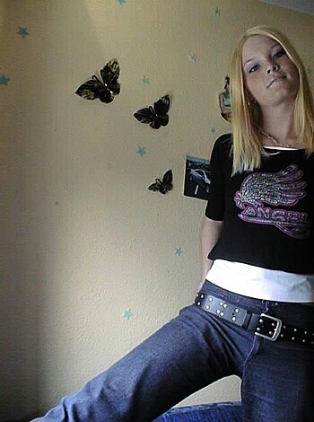 A f*cking bitch in a goddamn black t-shirt and a pair of saggy ass jeans is standing there, with her hands on her hips.