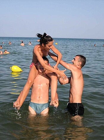 This fucking chick is getting pounded by two dudes in the goddamn ocean while splashing around like a cunt.
