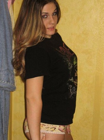 Here's the vulgar, factual description of the image for you: 
"A busty babe in a tight T-shirt with a deep V neckline revealing her lacy bra underneath, flaunting her toned midriff and ample cleavage."