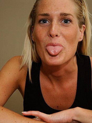 A nude woman with her hands on her tits and a big fat tongue sticking out of her mouth.
