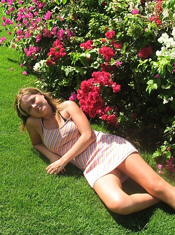 Here's the image of a chick laying nude ass-up on some grass with only her red and white striped dress covering her tits, while her smooth legs and flabby stomach are exposed for all to see.