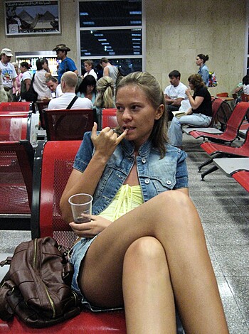 Blowjob cafe woman drinkin' java and talkin' shit on her cell phone at the airport.