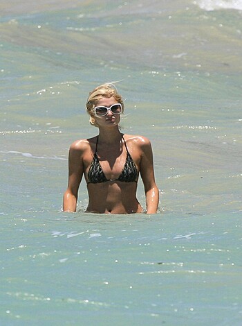 Vulgar description: Bitch is strutting her ass around in a skimpy bikini, tits out, flaunting her sexy body while walking on the shore of some tropical paradise.