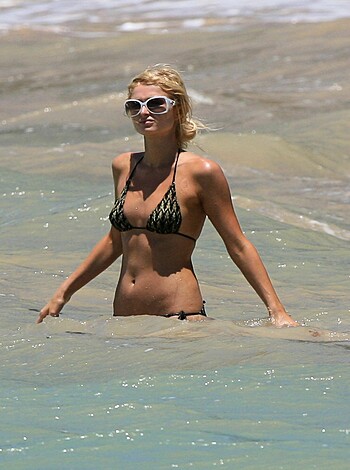 """
An attractive blonde in a skimpy bikini flaunting her curves on the sandy shores of some exotic beach destination.
"""