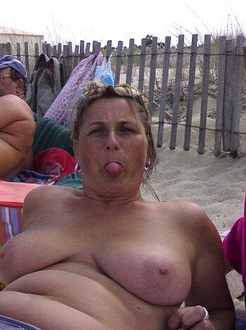 A bare-titted babe lounges by the shore and soaks up some rays, her perky nipples poking through her pink bikini top like two hardened teats on a milking machine.