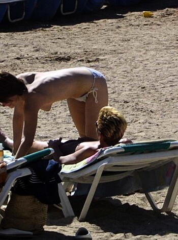 A naked chick flashes her ass while bending over some dude's face, on a beach.