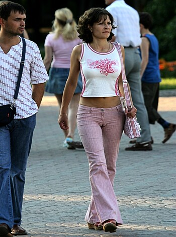 "This chick's got her boobs almost spilling out of her shirt, showing off that tight body with some skintight pants."
