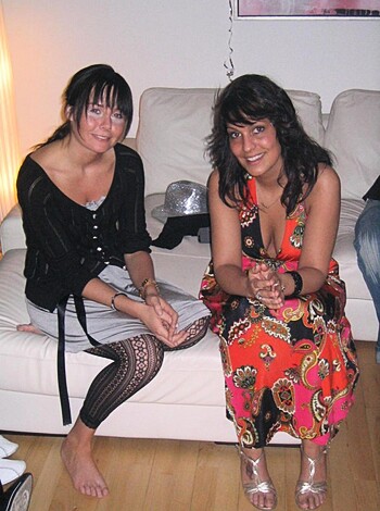 Damn right! Two smoking hot chicks sitting on a couch, with one dressed in a friggin' red and orange number that looks like it was made for stripping. Don't mind if I do!