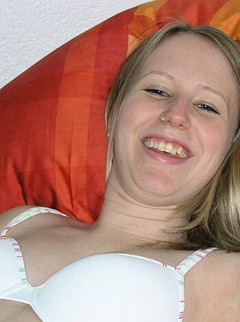 "Smiling, braless babe lying face-down on the mattress."