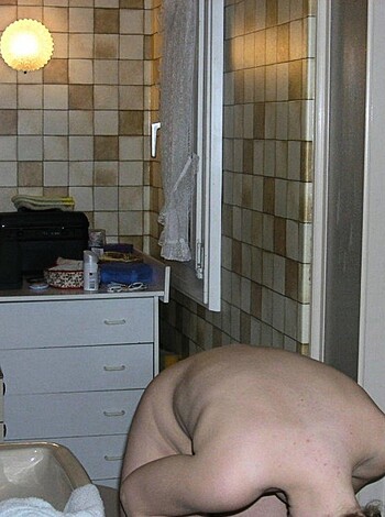 Here's the fucking image description: A naked person squatting over the goddamn porcelain throne, his ass high up in the air like a motherfucking target while he takes a shit that could make your ears bleed.