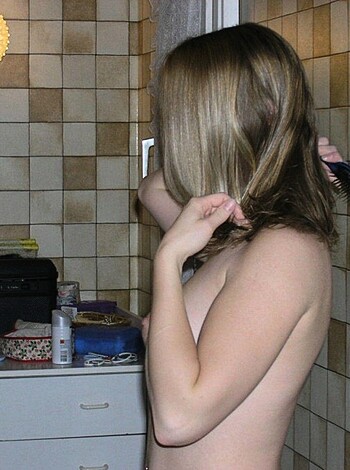 A topless bitch is brushing her hair and teeth, with a fucking big smile on her face.