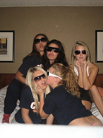 A bunch of chicks with shades and lipsticked mouths, lying naked on a mattress.