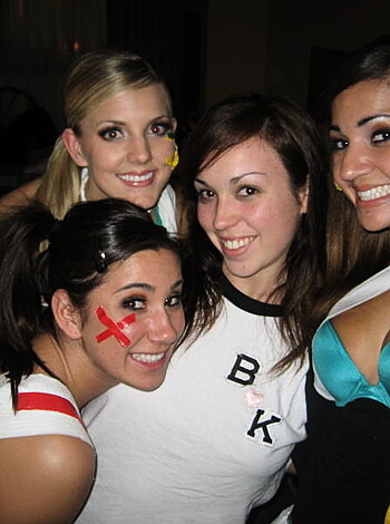 A bunch of busty chicks posing with forced smiles for the camera while showing off their skimpy underwear.