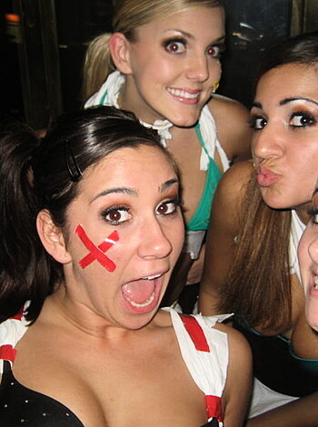 A photo of four hot chicks with wounds covering their tits and grinning while striking a pose for the camera.
