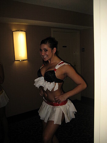 A chick in a skimpy bikini top and ass-hugging shorts grins like a fucking idiot in some shitty hallway at goddamn midnight.