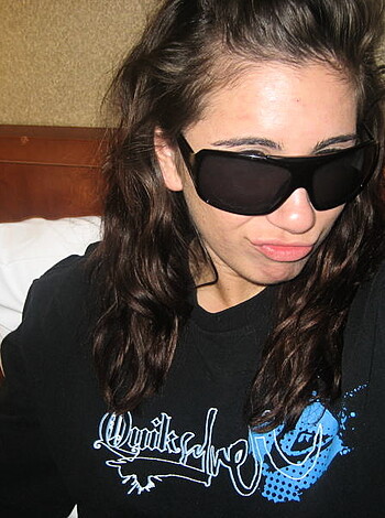 """
This is a fucking photo of some hot slut laying in her bed with her sexy ass shades on, looking all fucking pissed off.
"""
