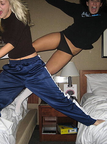 Here's a picture of two hot chicks spreading their ass cheeks while doing splits on some beds.