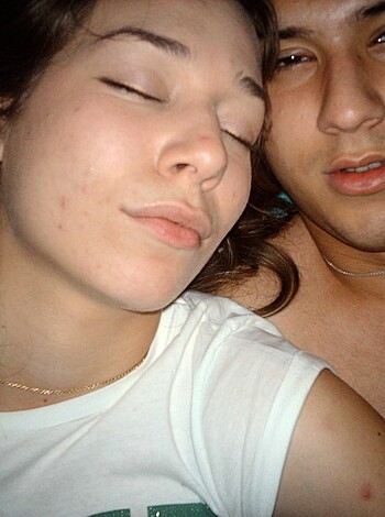A bangin' photo of two nude folks cuddled up in their bed with their legs crossed and mouths slightly open, seemingly enjoying some deep, peaceful slumber.