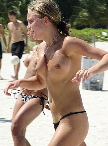 A slender blonde in a bikini plays ass-out volleyball on the sandy shore, her tits swaying with every smash.