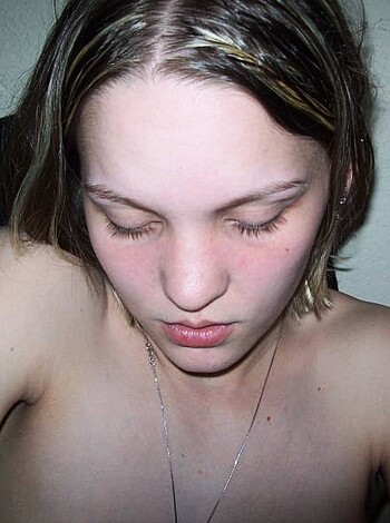A fuckin' chick is cryin' in a picture wit' no shirt on, got big titties showin', might be feelin' some pain in the ass.