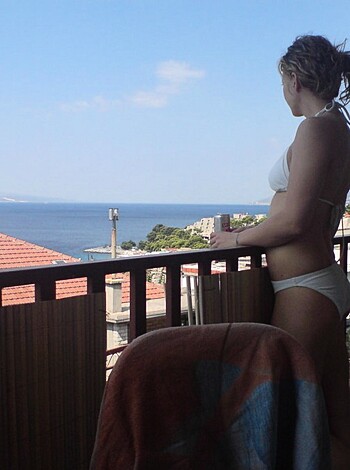 The naked, tanned bitch is flaunting her big tits and shitty ass.