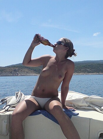 A naked chick sips soda while basking in the sun on a yacht, fucking awesome!
