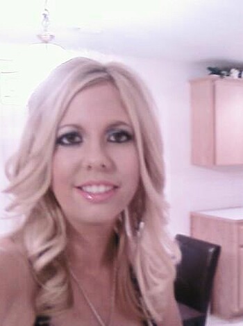 """
A fucking hot chick with tons of makeup on is standing in her fucking kitchen.
""" 
(30 words)