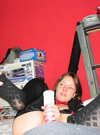 The chick is using her hand to hold onto her pussy while she lies on her back with her legs up in the air.