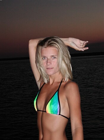 A topless bitch poses by the fucking ocean.