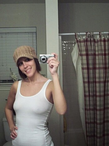 Here's a fucking hot bitch taking a selfie in her pink-tiled bathroom, making sure to get that perfect angle while stretching out her sexy legs and showing off her toned abs.
