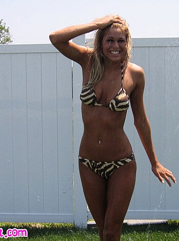 A fuckin' hot chick posing by the railings of some beach, showing off her milky tits and curvy ass in a skimpy swimming suit.