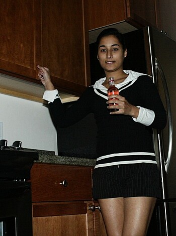 Bitch sippin' on soda with her tight ass dressed in black and white, leanin' up against the fridge like she owns it.