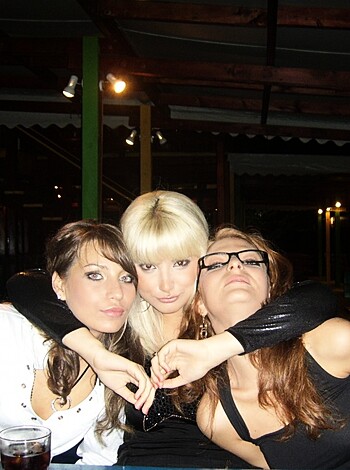 "Here are two slender bitches in dark attire, posing with their palms joined together while the third blonde chick leans over with her hand on her hip."