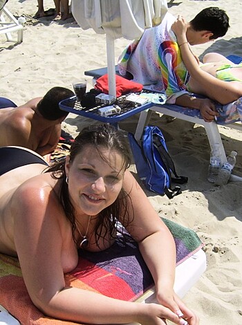 A naked broad lounges on some sandy shore, taking in rays that bounce off her fucking body.
