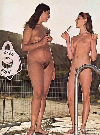 A poolside photo of two nude chicks giggling and poking at their pussies.