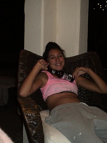 This chick's taking it easy, lazing about on her pink tank top and jeans-decked ass while she enjoys the sunshine with her face all tilted back and happy as fuck.